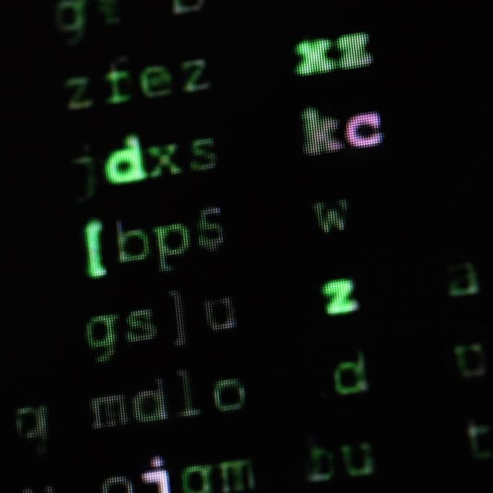 A random string of letters in green and pink on a black background