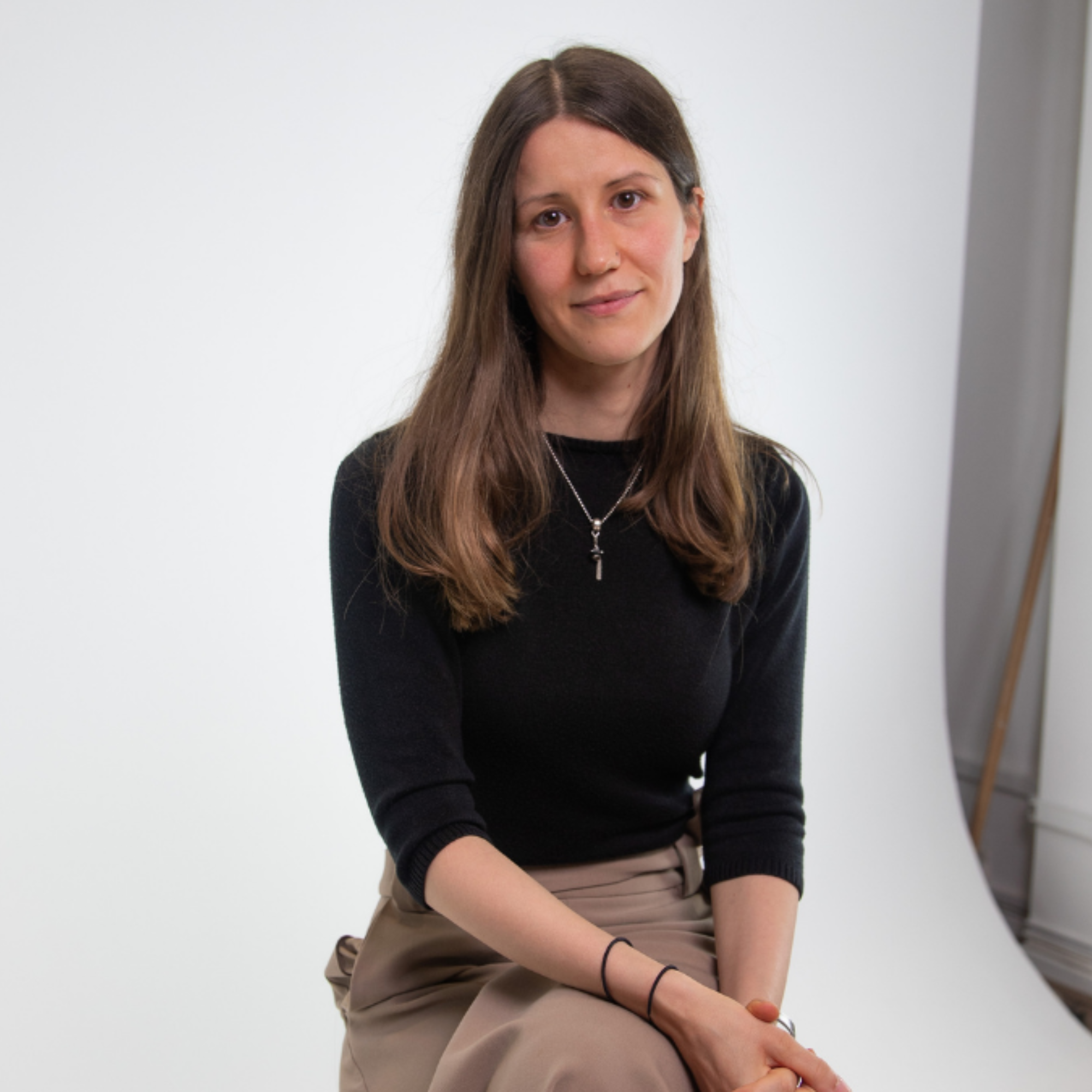 Professor Sandra Wachter sits in a photography studio in front of a white backdrop
