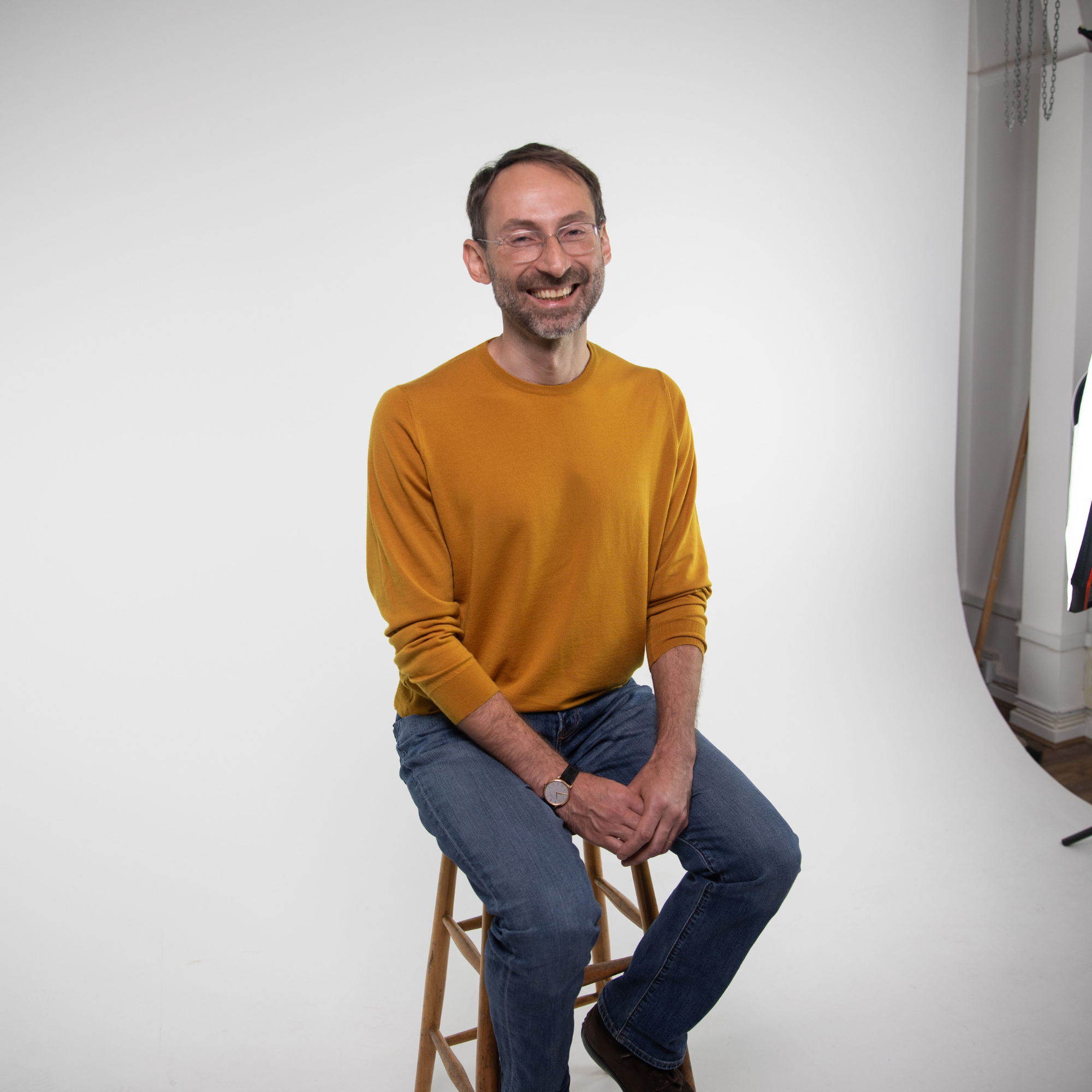 Professor Michael Bronstein sits in a photography studio in front of a white backdrop