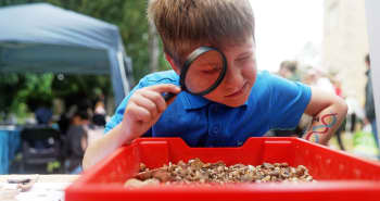 Image of a boy looking through a magnifying glass