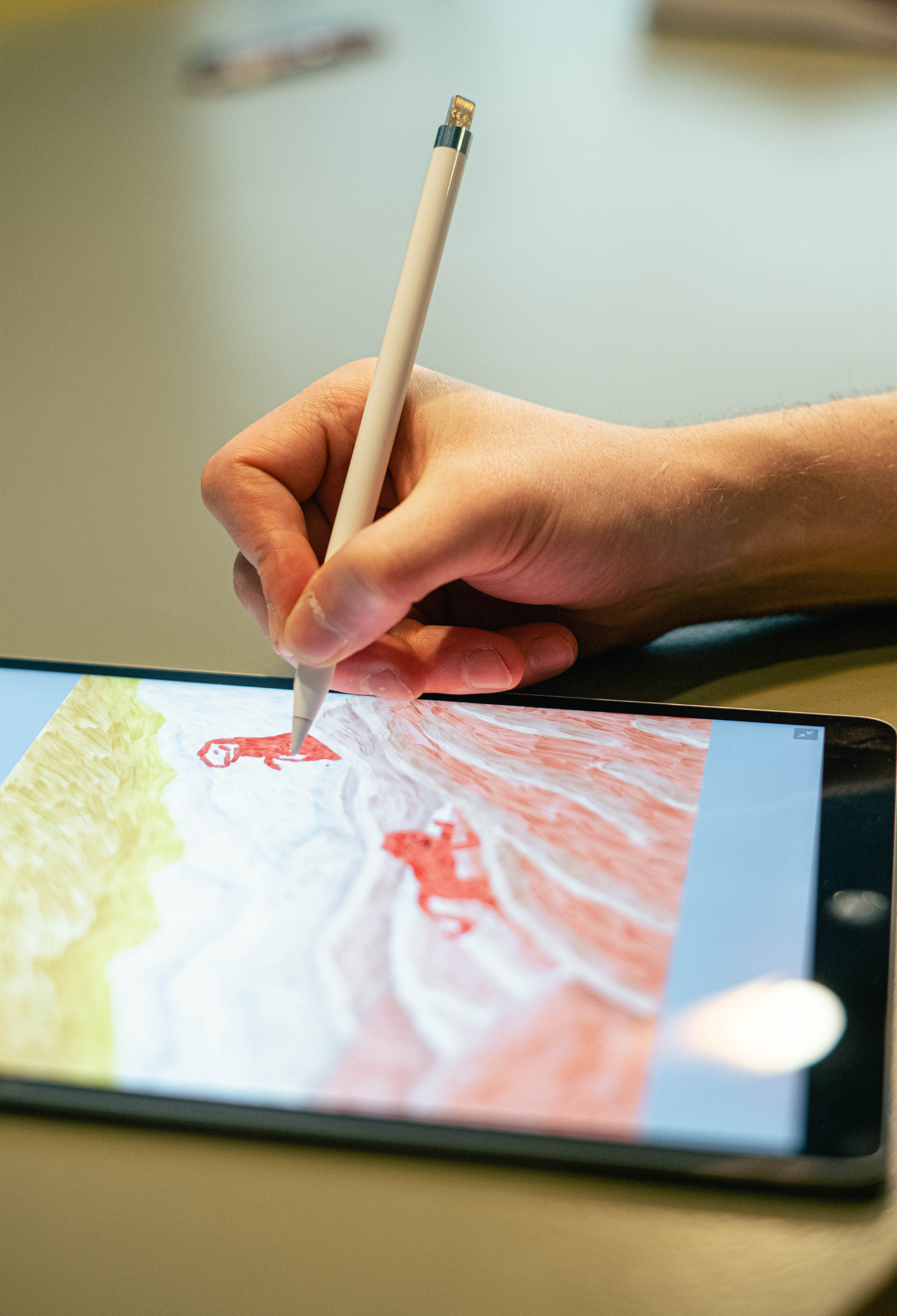 Someone using a stylus to draw on a digital tablet