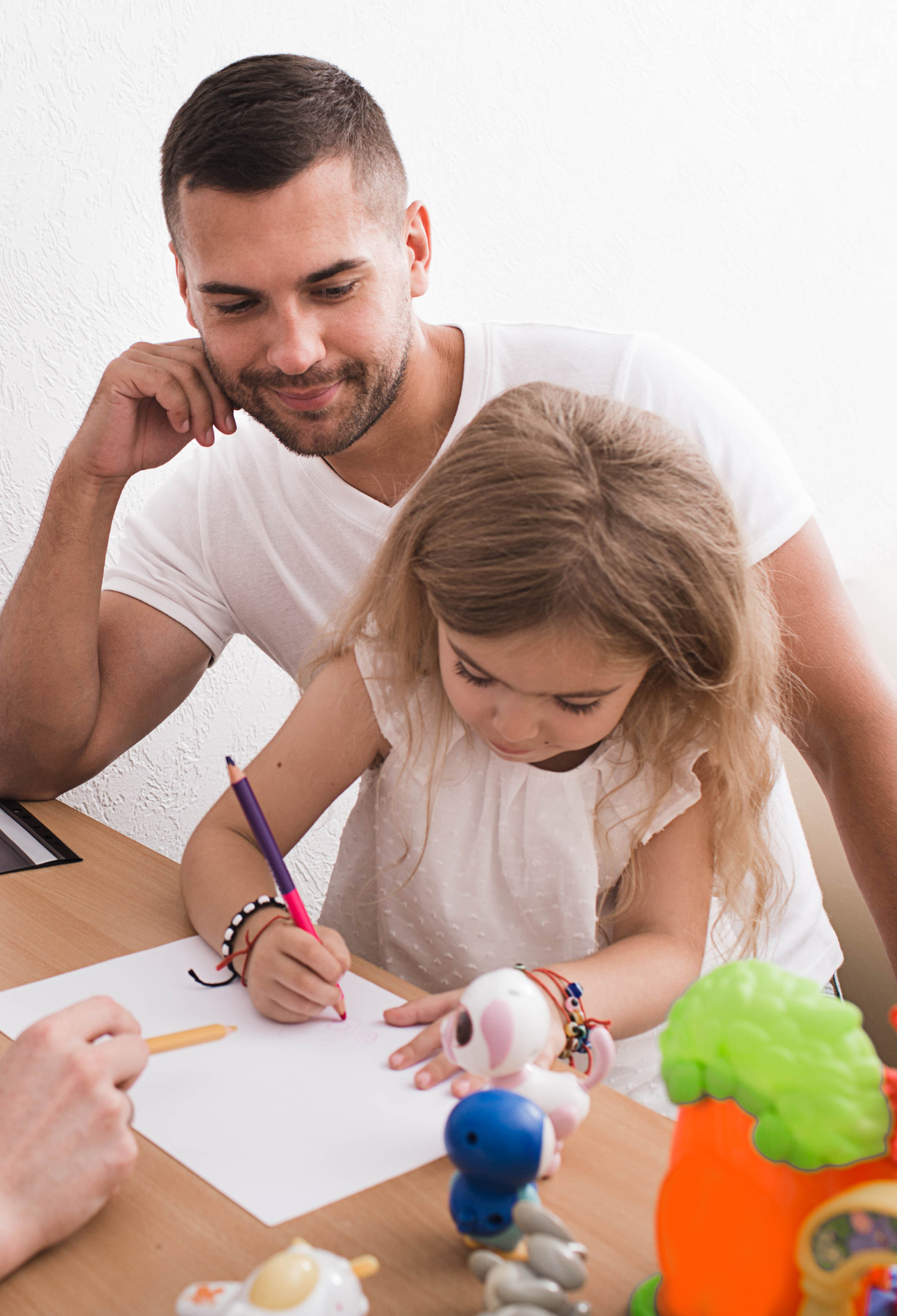 A parent and child sit at a table, writing