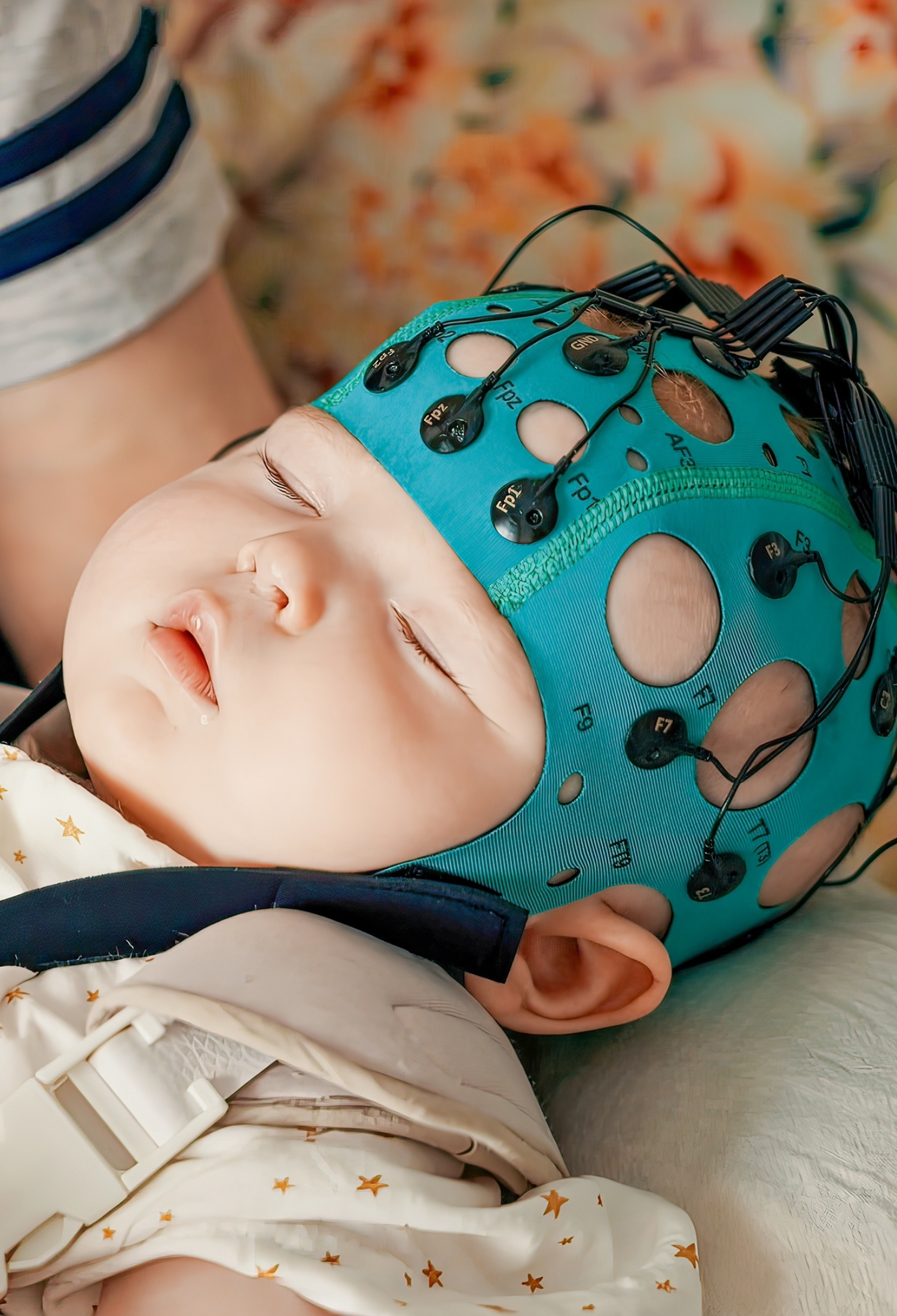 A young baby in brain-monitoring headgear