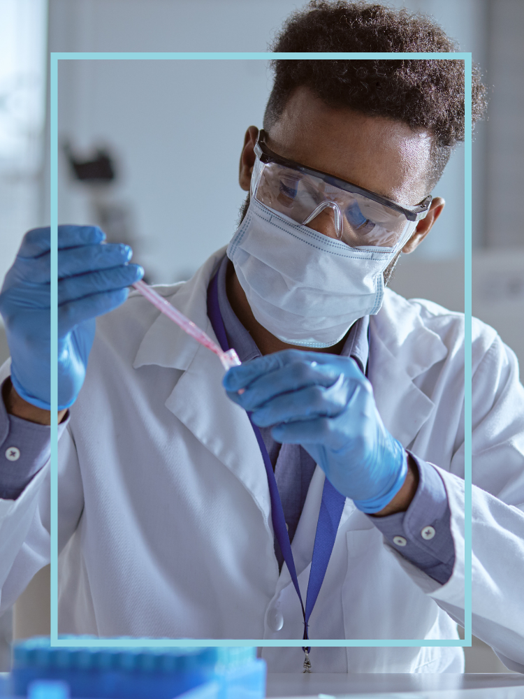 A researcher dropping liquid from a pipette into a tube