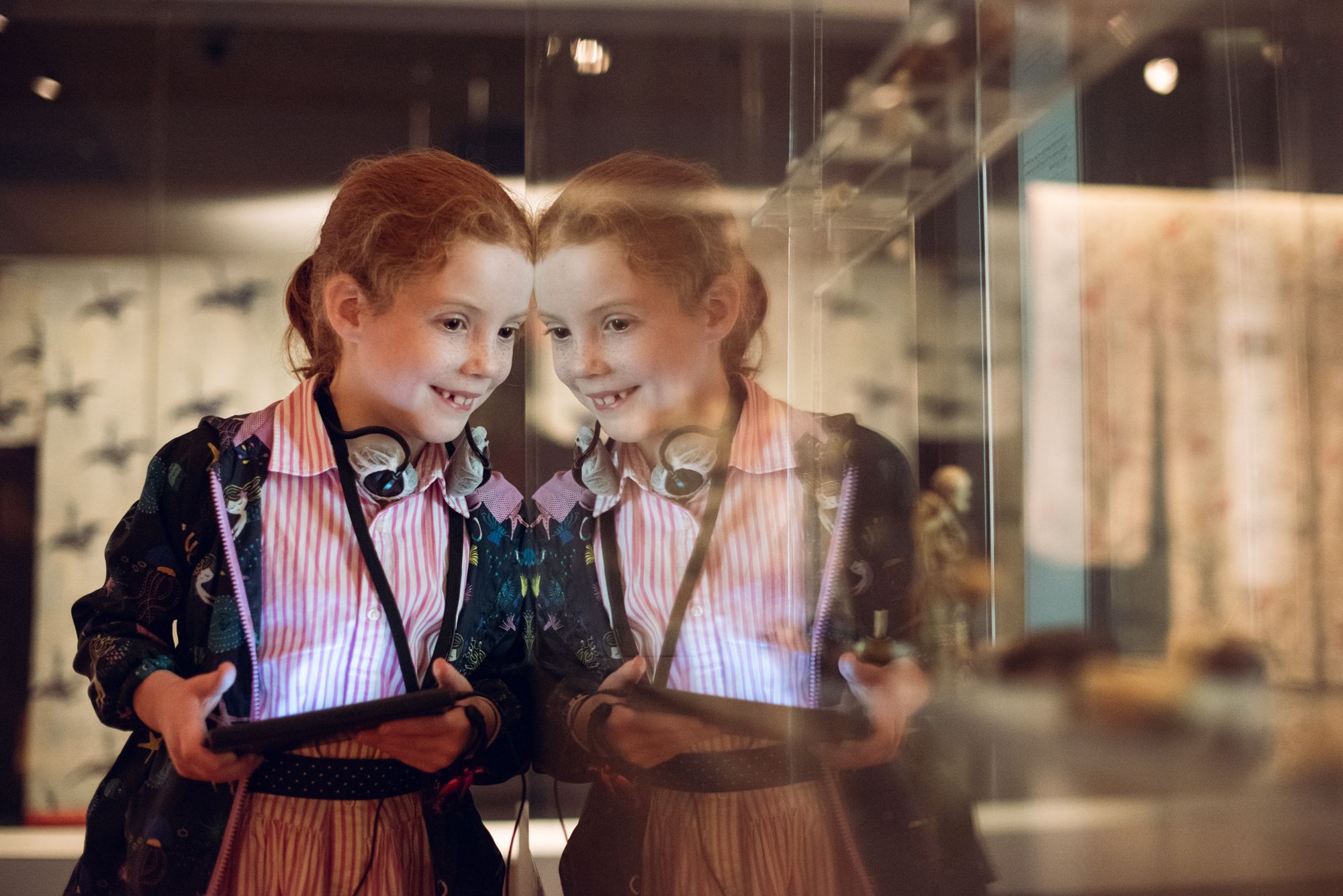 A child inside a museum with an audio player