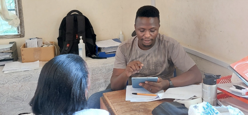 A Zimbabwean healthcare worker discussing epilepsy with a patient in a clinical setting