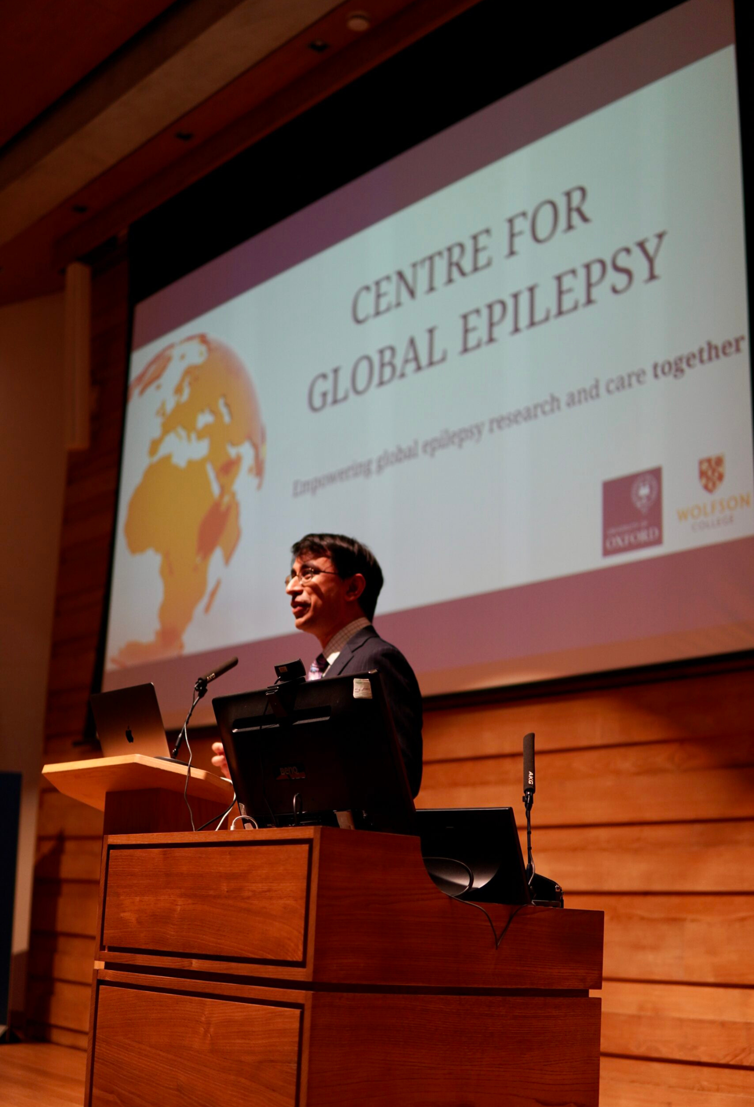 Professor Arjune Sen stands in front of a presentation slide that reads 'Centre for Global Epilepsy'
