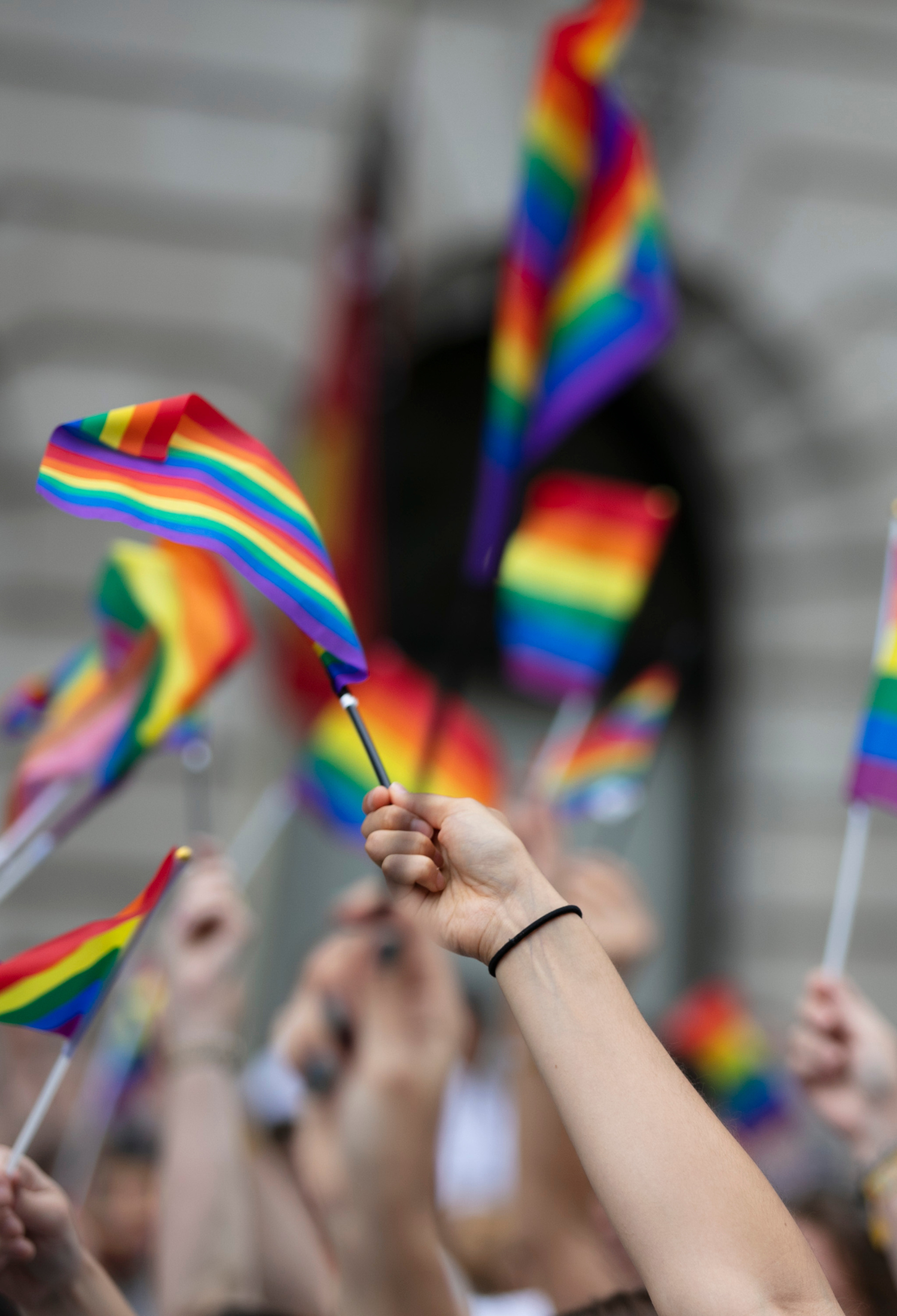 Crowd of people waving pride flags 