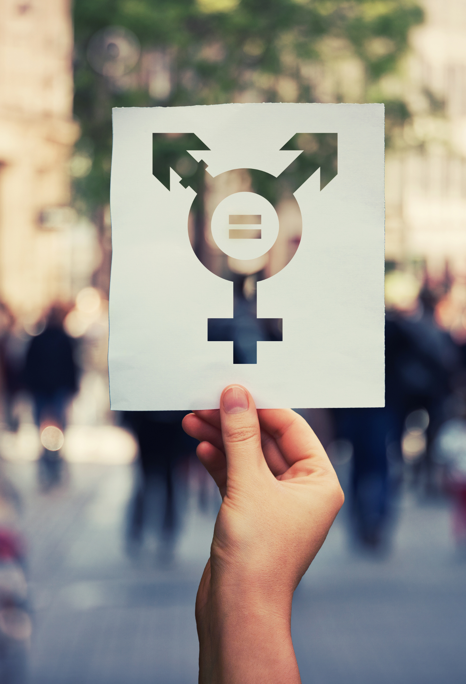 Hand holding up a piece of paper with transgender symbol on it