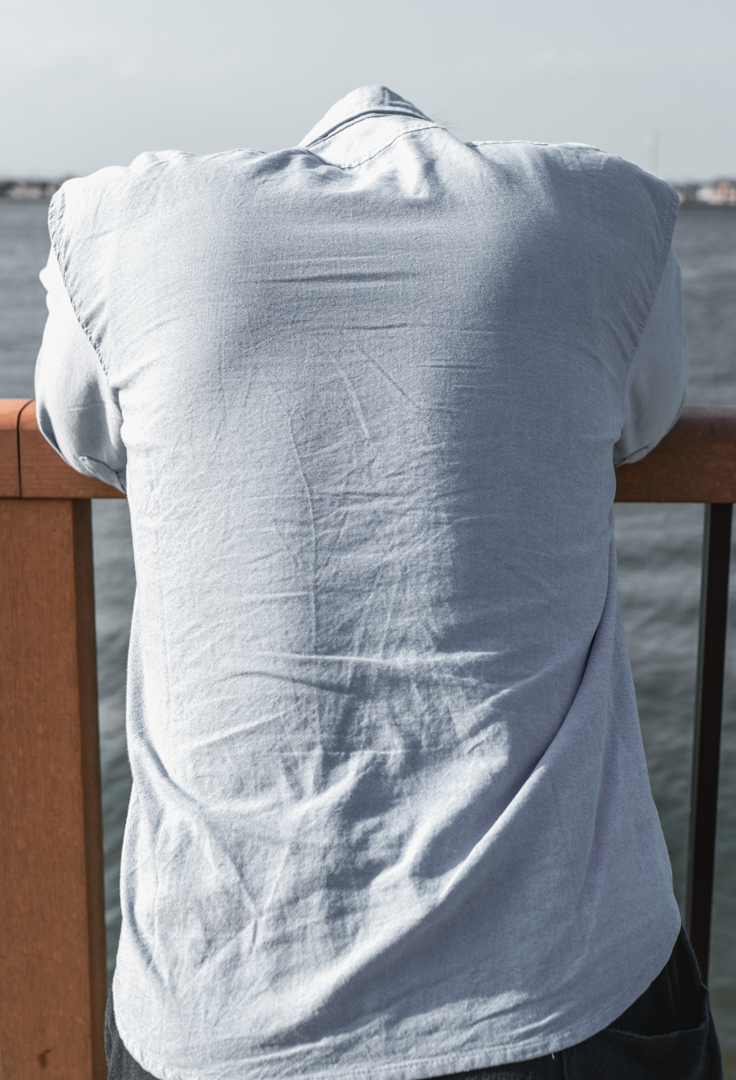 Man leaning on railing with head hanging down