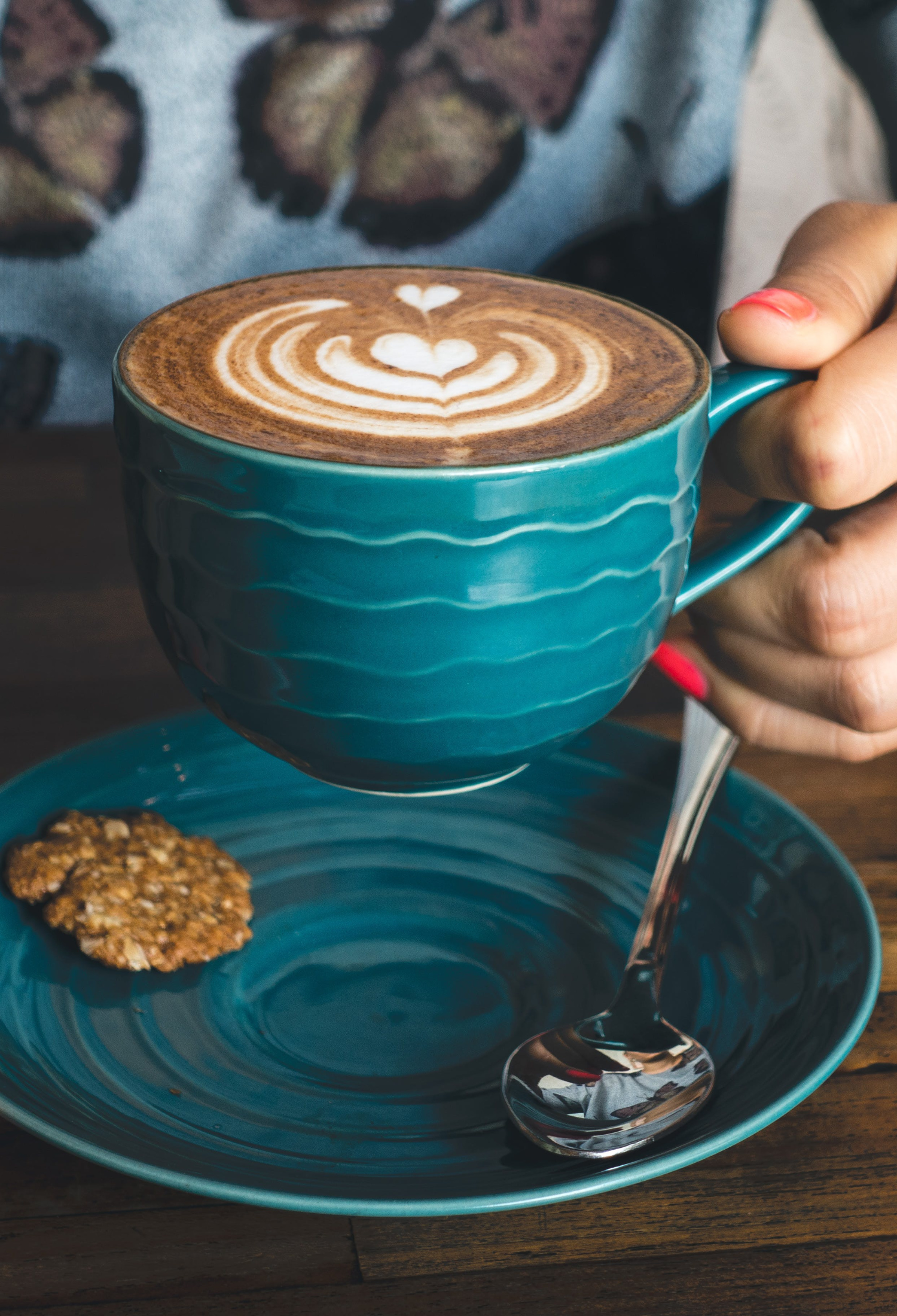Someone holding a hot drink in a cafe