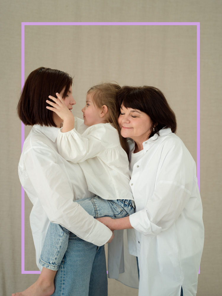 Two women hugging a child