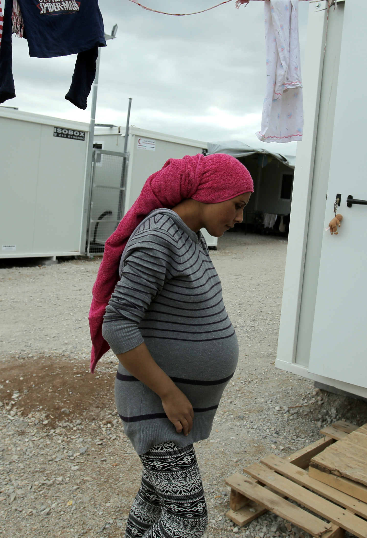 A pregnant woman outside temporary accommodation