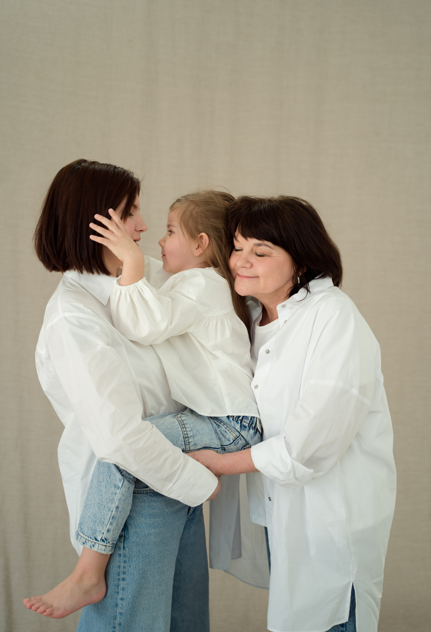 Two women hugging a child