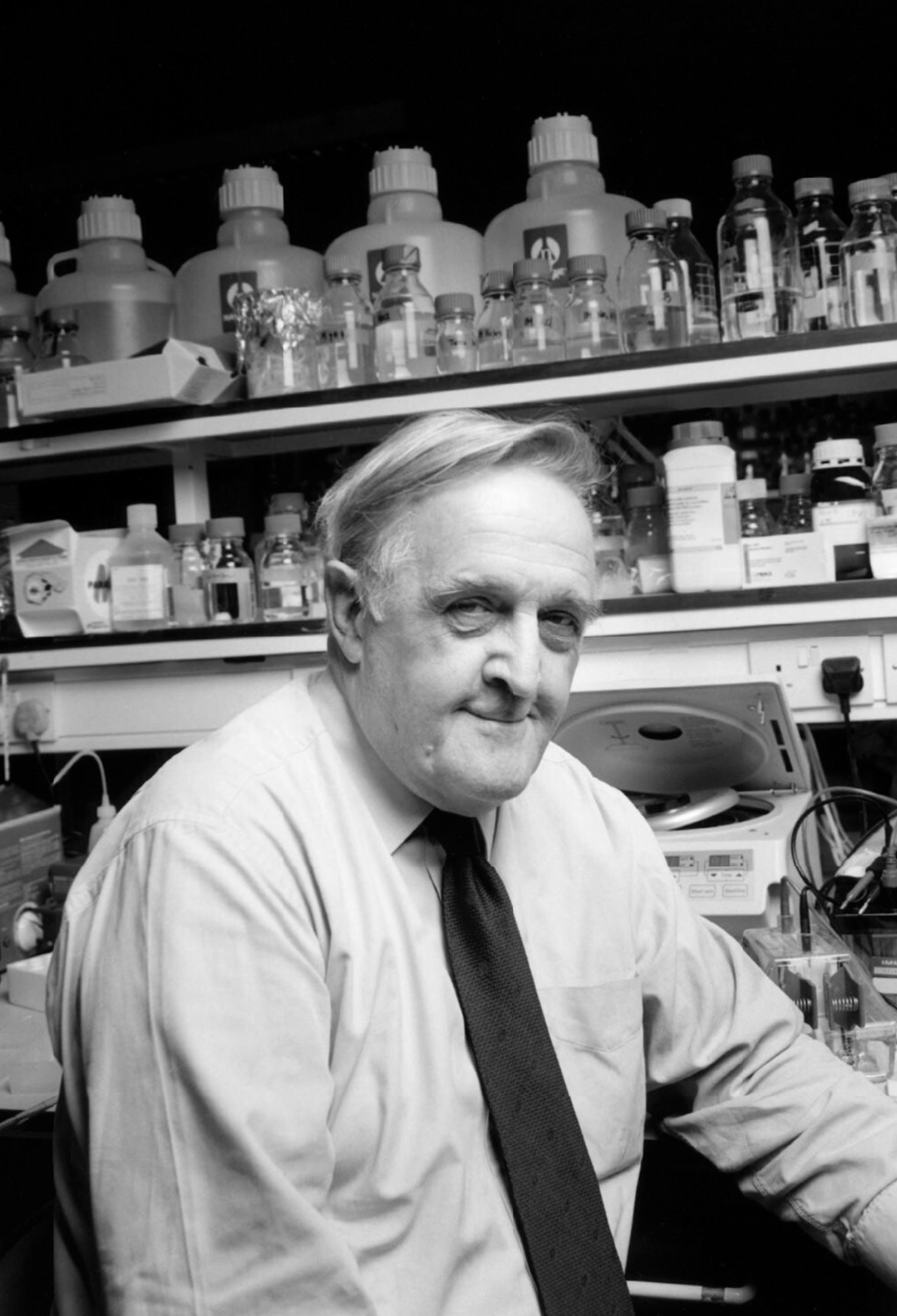 A black and white photo of Professor Sir David Weatherall in the lab