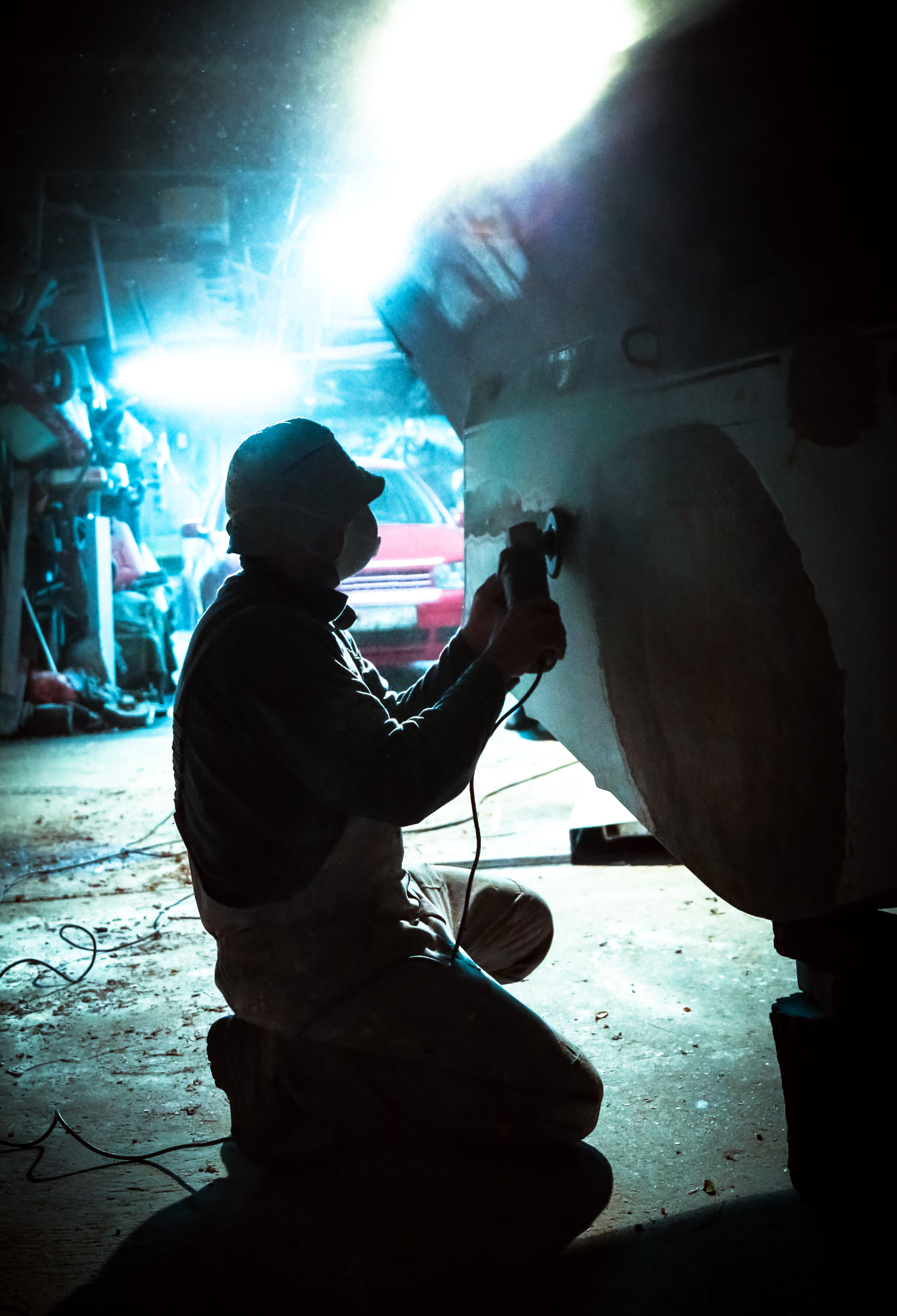 A man is working in a garage late into the night